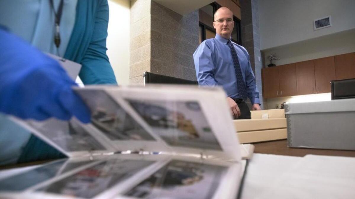Lacey city manager Scott Pence looks over some of the estimated 80,000 pictures that his staff are pulling to fulfill a public records request for “every photo” in the city archive, shown at Lacey City Hall.