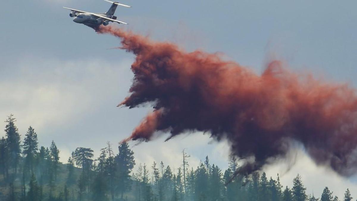 An airplane tanker drops fire retardant on a wildfire north of Twisp, Wash., Friday, Aug. 21, 2015. Massive wildfires expanding across arid Washington state have so overtaxed firefighters that the federal government declared an emergency and state officials took the unprecedented step of seeking volunteers to help fight the flames.