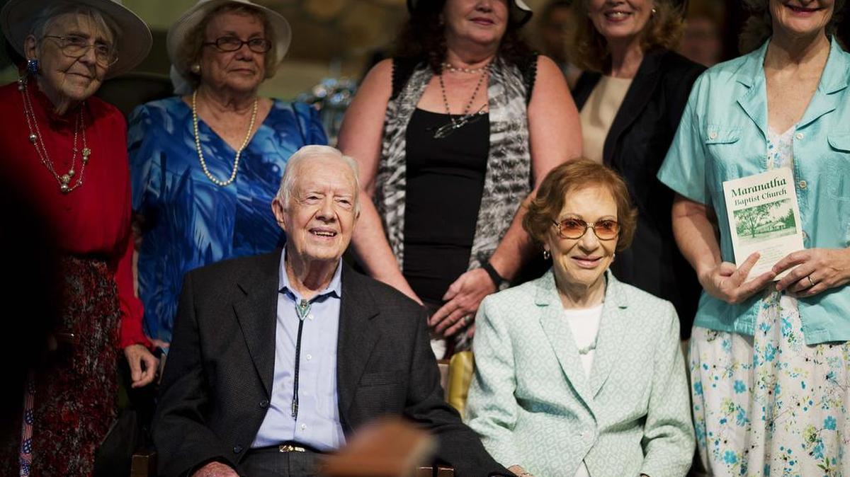 
Former President Jimmy Carter, left, sits with his wife Rosalynn as they pose for photos after Carter taught Sunday School class at Maranatha Baptist Church in his hometown Sunday, Aug. 23, 2015, in Plains, Ga. The 90-year-old Carter gave one lesson to about 300 people filling the small Baptist church that he and his wife, Rosalynn, attend. It was Carter's first lesson since detailing the intravenous drug doses and radiation treatment planned to treat melanoma found in his brain after surgery to remove a tumor from his liver. 
