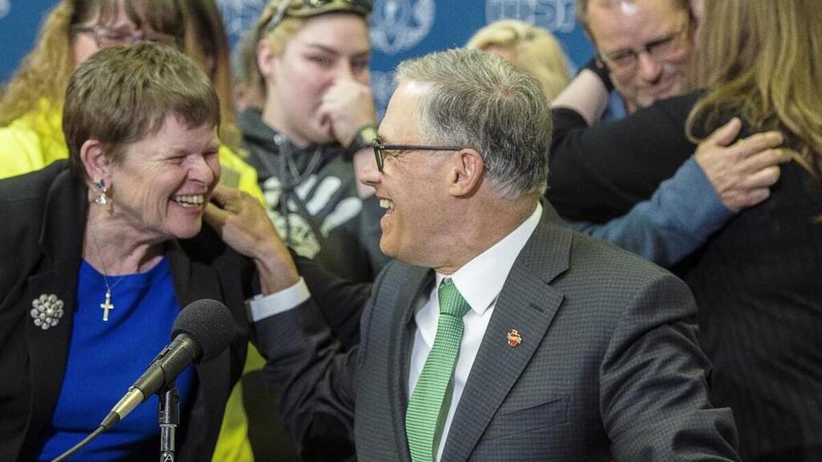 Gov. Jay Inslee, center, smiles with Lavera Wade, left, after signing a bill aimed at distracted driving at the State of Washington Combined Transportation Center in Tacoma, Wash., on Tuesday, May 16, 2017. Wade's grandson died after driving into the wrong lane and colliding with a semi truck while sending a text message.