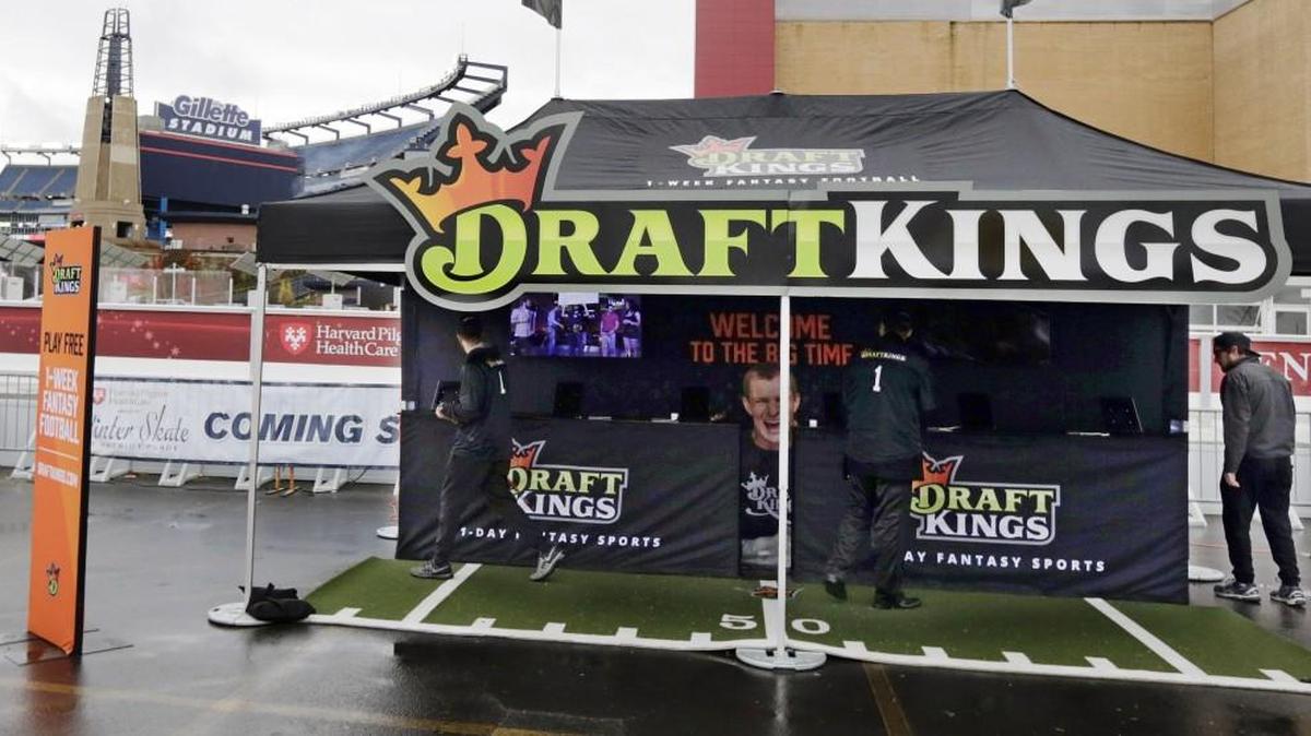 FILE - In this Oct. 25, 2015, photo, workers set up a DraftKings promotions tent in the parking lot of Gillette Stadium, in Foxborough, Mass., before an NFL football game between the New England Patriots and New York Jets. New York's attorney general on Tuesday, Nov. 10, 2015, ordered the daily fantasy sports companies DraftKings and FanDuel to stop accepting bets in the state, saying their operations amount to illegal gambling.