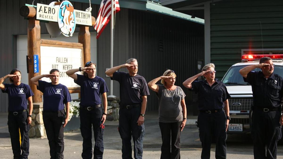 
First responders salute as the bodies of three firefighters are processed through the town of Twisp, Wash., Thursday, Aug. 20, 2015. Authorities say the firefighters died after their vehicle crashed and was apparently caught on flames as they battled a blaze in Washington state. 
