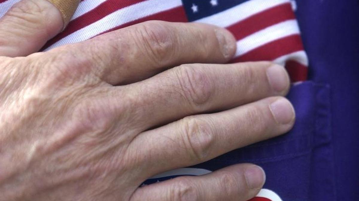 Flag Day organizer Gregory Moe of Olympia honors the flag during the Pledge of Allegiance. (Tony Overman/The Olympian)