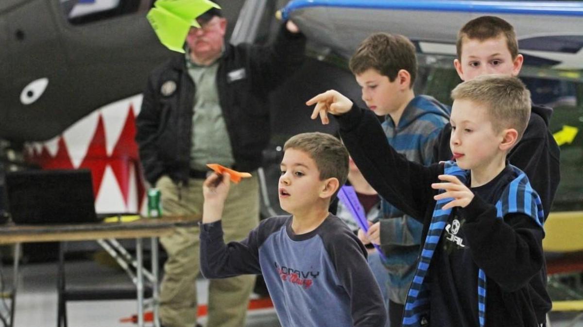 Jacob Matuszczak, left, and Jake Gray throw paper airplanes during the last heat of the accuracy competition during Olympic Flight Museum’s Paper Airplane Flight School in 2013.