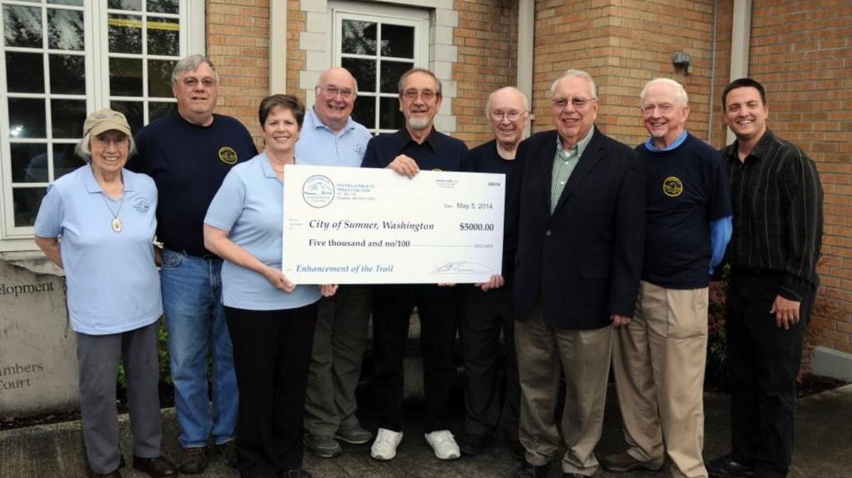 Buzz Grant, fourth from left, has been president of the Foothills Rails-to-Trails Coalition for six years. He is shown here presenting $5,000 to the City of Sumner for the Sumner Link Trail in 2014.