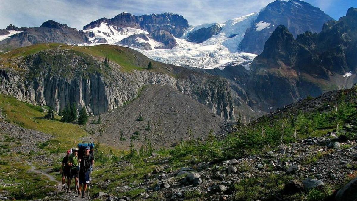 Tahoma Glacier glistens on the west flank of Mount Rainier as Thad Richardson, right, Matt Misterek and Craig Hill hike on Emerald Ridge along the Wonderland Trail in 2012.