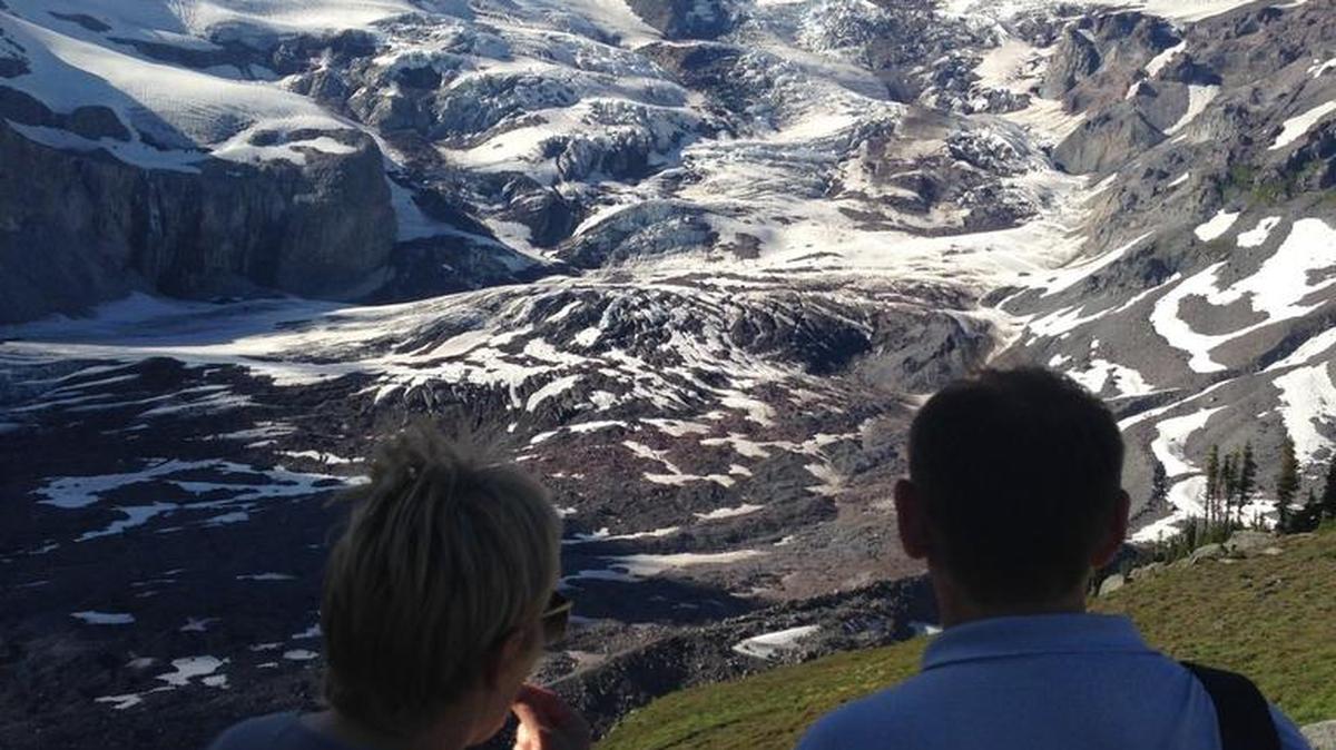 A pair of hikers above Paradise take in the view of Mount Rainier and the Nisqually Glacier on Aug. 11.