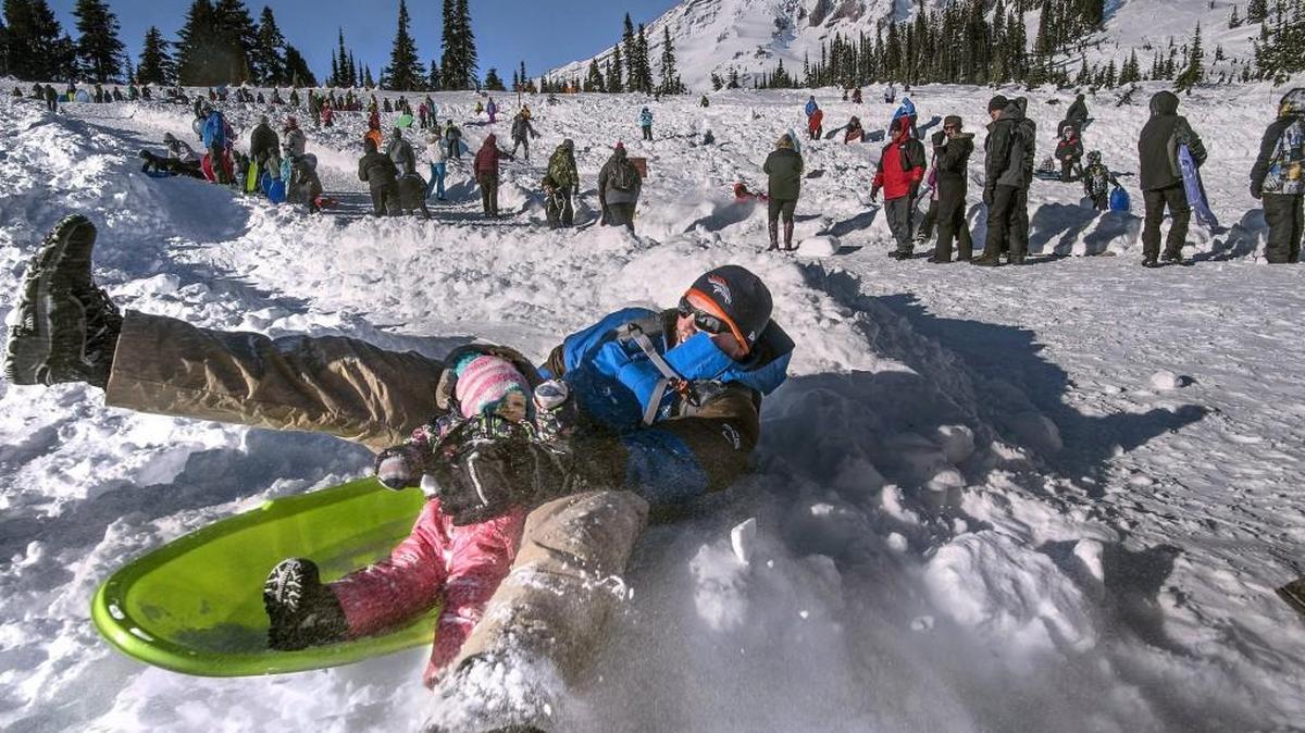 Cory Petersen of Granite Falls attempts to hold onto 18-month old daughter Emma as he sledded in January. Mount Rainier National Park plans to open the snowplay area for the 2016-17 season on Friday.