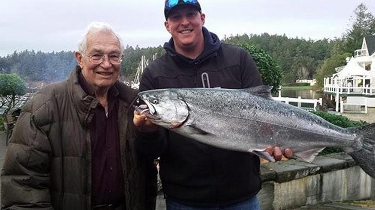 Duke Fisher, right, of Burlington holds the 17-pound, 12-ounce salmon he caught to win the Roche Harbor Salmon Classic and the $10,000 first-place prize. His grandfather, Bob Fisher, stands with him.