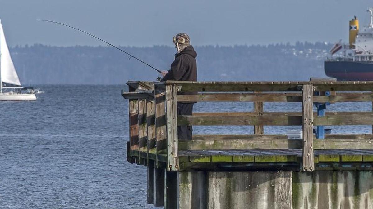 An angler fishes off the Les Davis Pier at Marine Park in Tacoma.