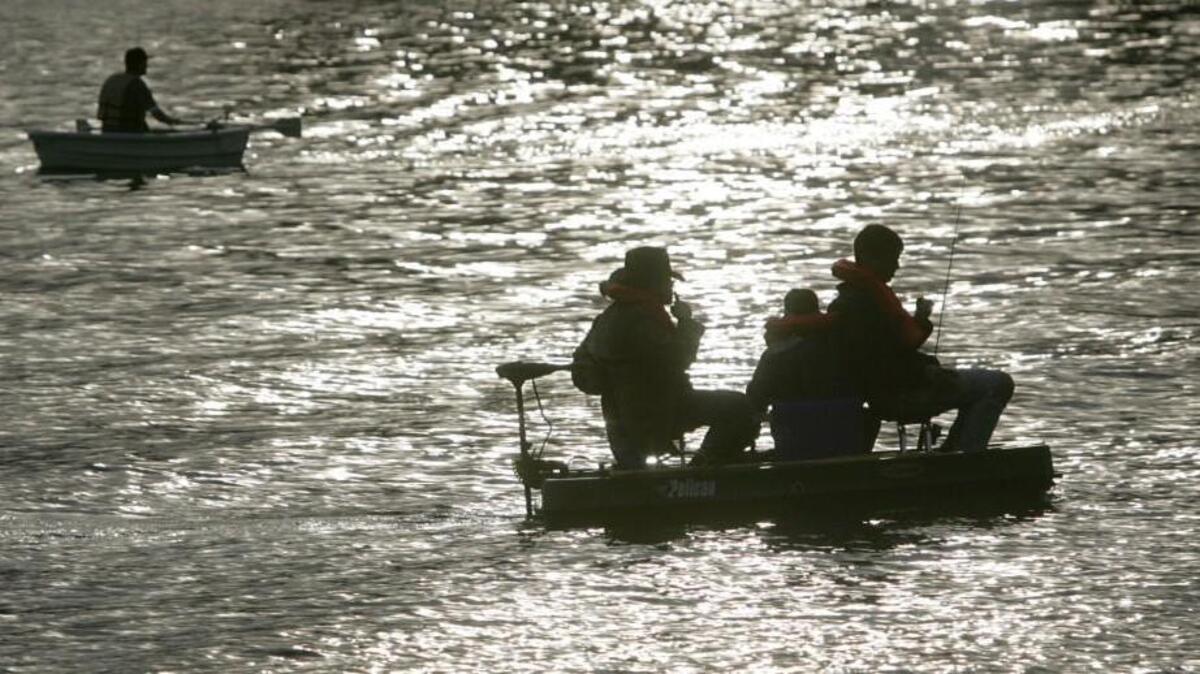 Jeff White, Whitney White, and Travus Pople from Milton try their luck at Spanaway Lake with other anglers including Darrell Mills, background, of Parkland in 2006.