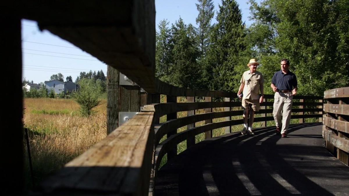 Ernie Bay, left, a trail activist from Puyallup, walks the Nathan Chapman Memorial Trail with Sen. Jim Kastama in 2005. The trail is named after the first U.S. casualty in Afghanistan, Nathan Chapman from South Hill. Bay, who dedicated years to South Sound trails, died March 18.
