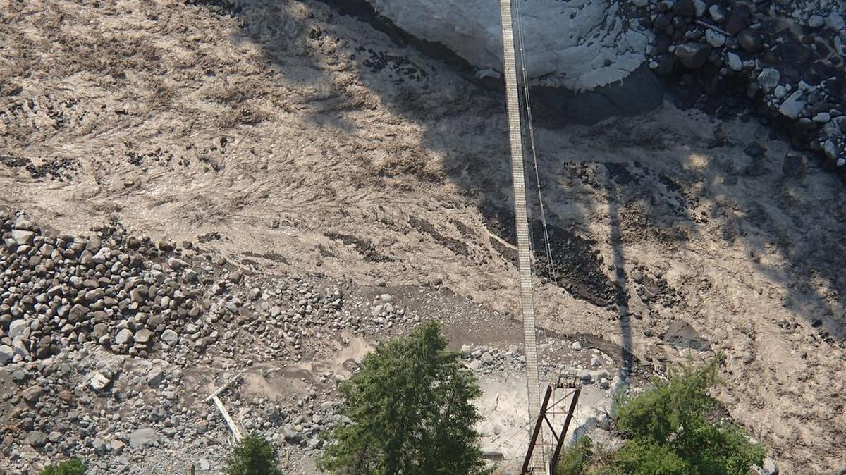 
A torrent of water and debris from a glacial outburst Thursday flows under a suspension bridge near Indian Henry's Hunting Ground at Mount Rainier National Park.

