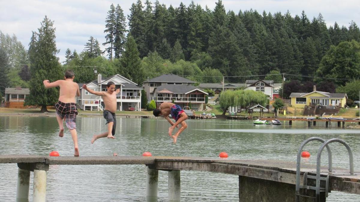 
Kevin Crum, from left, Nicolo Ponnekanti and Tyler Olson jump off the dock into Lake Tapps at Allan Yorke Park in Bonney Lake.
