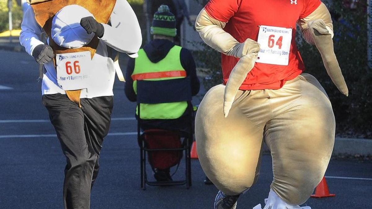 Missing only the gravy while dressed as a slice of pumpkin pie and the main course were Dan Bell of Snohomish (No. 66) and Darrel Bell (No. 64), near the finish line during the 2015 Oly Trot 4-Mile Run in downtown Olympia.