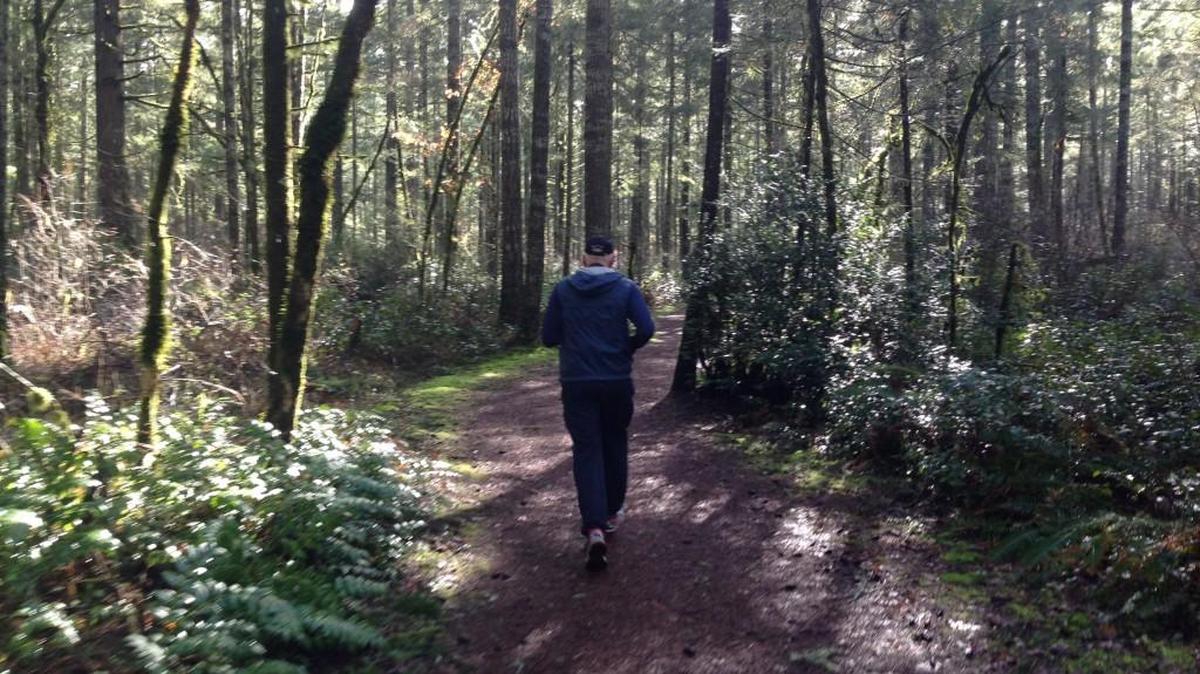 A jogger logs his miles on the winding Huff ’n’ Puff Trail near Shelton High School.