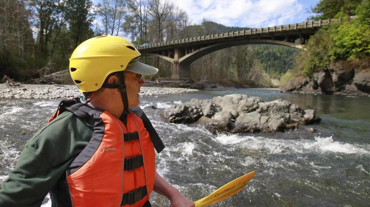 In this file photo from 2014, a staff member of the National Parks Conservation Association approaches the Highway 101 bridge during a rafting tour of the Elwha River. This area was underwater as part of Lake Aldwell before the Elwha Dam was removed in 2012.