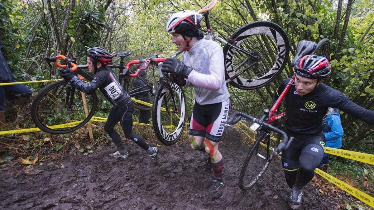 Competitors in the 2015 Subaru Cyclo Cup cyclocross race carry their bikes through an intentionally muddy run-up in an open race for men 35-and-under and two masters categories, 55-plus and 60-plus at Fort Steilacoom Park.