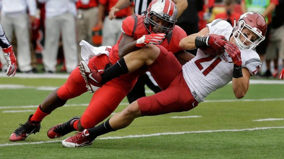 
Washington State’s River Cracraft (21) dives for yardage as Rutgers’ Quentin Gause makes the tackle in the first half Saturday. Cracraft finished with eight receptions for 121 yards, including the winning touchdown with 13 seconds left. 
