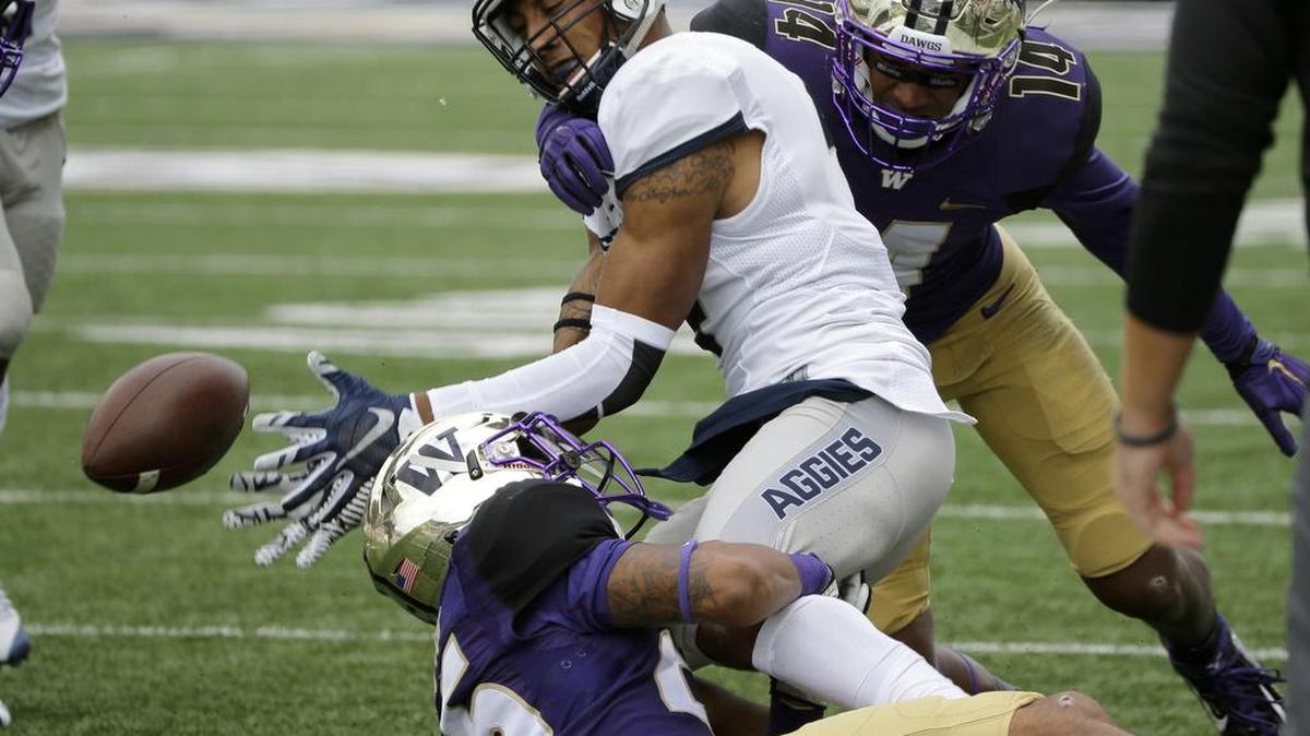 UW’s Sidney Jones, on turf, helps force a Utah State fumble. He forced three fumbles, had four picks in 2015.
