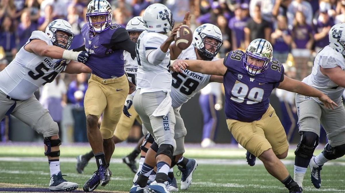 UW linebacker Travis Feeney, left, and lineman Greg Gaines, right, fight off blocks to pressure Utah State quarterback Chuckie Keeton. Photo taken at Husky Stadium in Seattle on Saturday, Sept. 19, 2015.