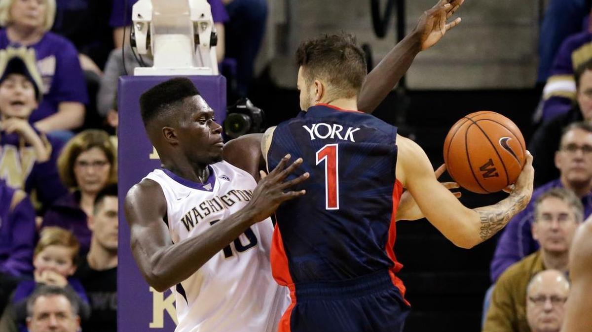 UW’s Malik Dime, left, tries to block a shot by Arizona’s Gabe York on Saturday afternoon. Dime played a career-high 33 minutes and finished with 10 points and four blocks. York had 18 points.