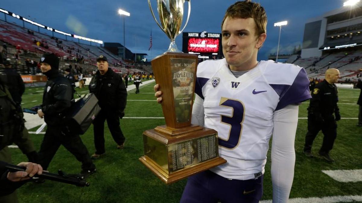 Washington quarterback Jake Browning walks with the Apple Cup trophy after the Huskies defeated the WSU Cougars this past Friday. Browning was voted Offensive Player of the Year and was one of a UW-record nine players voted to the All-Pac-12 first team on Tuesday.