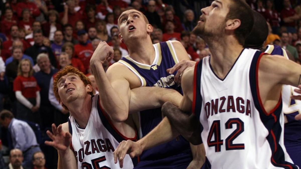 Washington’s Hans Gasser, center, and Gonzaga’s David Pendergraft, left, and Josh Heytvelt battle it out at the McCarthy Center in Spokane in 2006. UW and the Zags haven’t played each other on their campuses in 10 years.