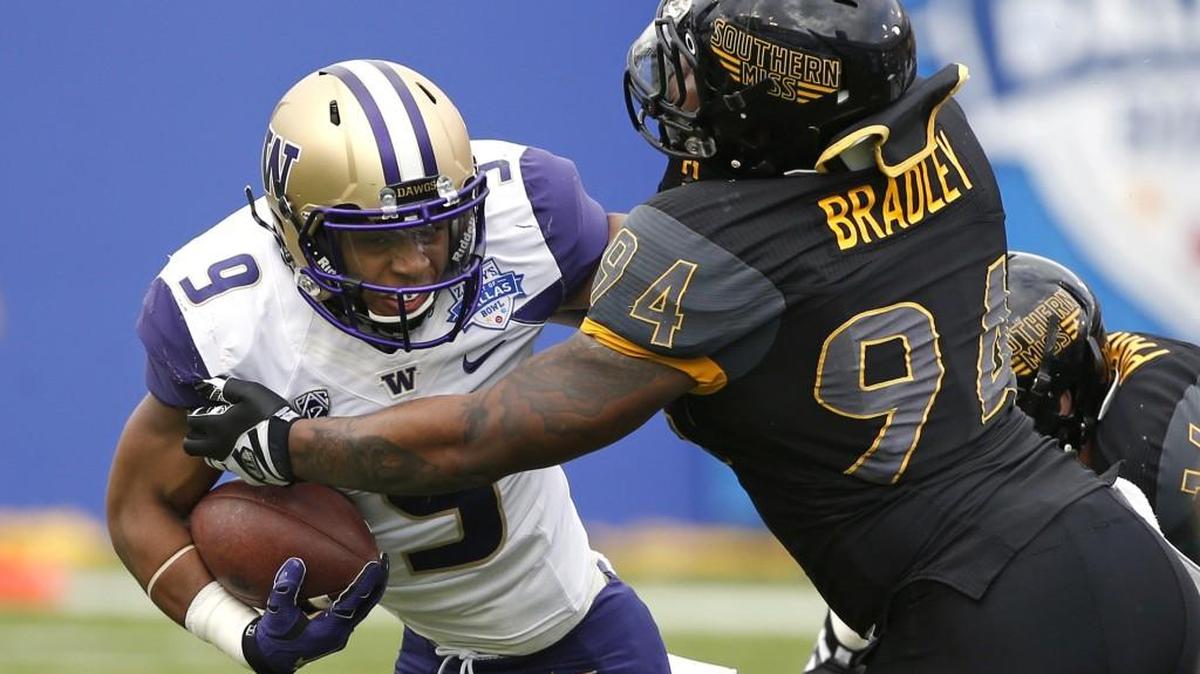 Washington fullback Myles Gaskin, left, runs against Southern Mississippi defensive lineman Dylan Bradley during the Heart of Dallas Bowl. Gaskin was named the game’s Most Valuable Player after running for a season-high 181 yards on 26 carries, scoring four touchdowns.
