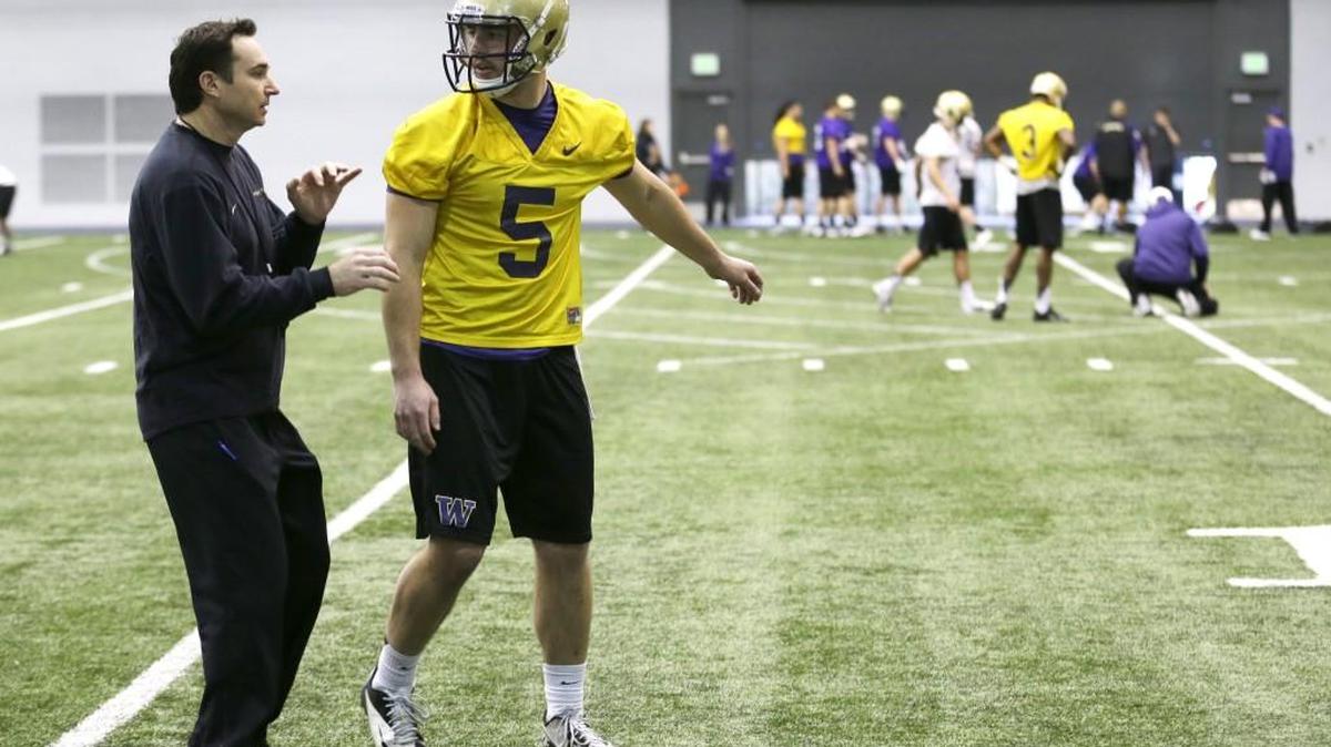 UW offensive coordinator Jonathan Smith, left, talking with QB Jeff Lindquist, has come under fire for the Huskies’ offensive struggles.