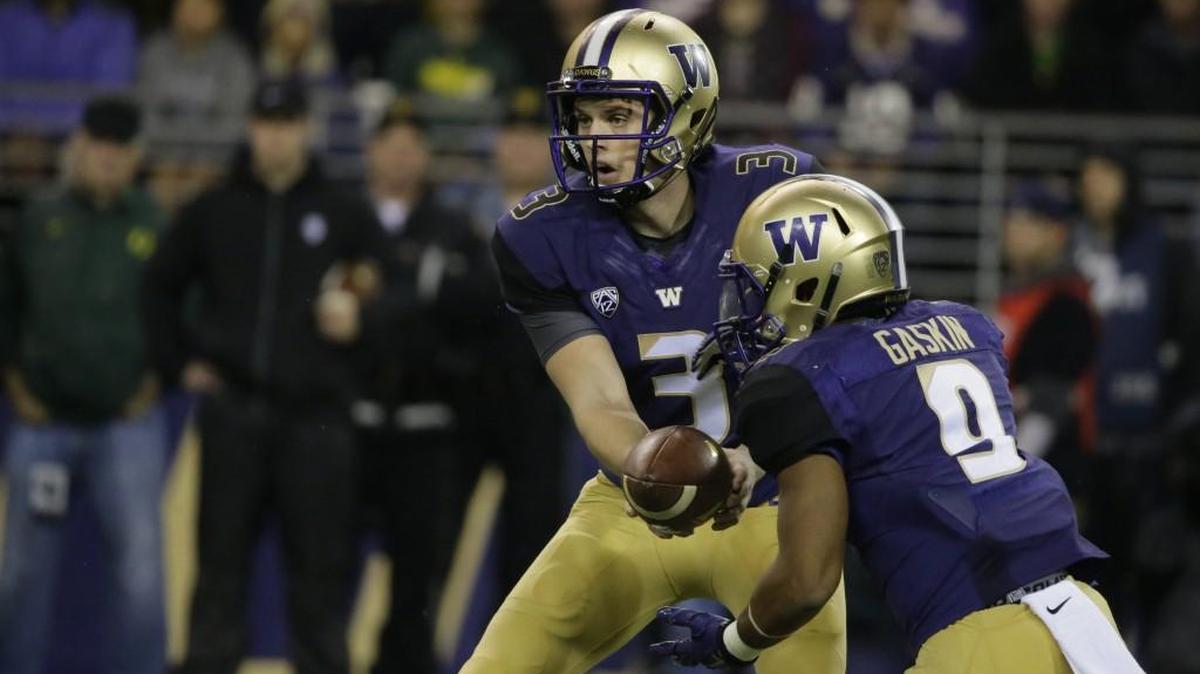 
Washington quarterback Jake Browning hands off Myles Gaskin, right, in the first half Saturday. Browning later injured his shoulder. 
