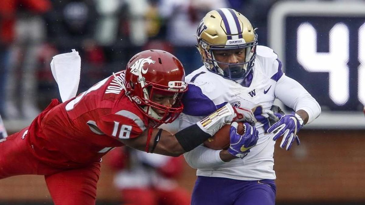 Washington wide receiver John Ross (1) tries to shake off a tackle by Washington State cornerback Treshon Broughton (16) in the second quarter. The Washington Huskies played the Washington State Cougars in the Apple Cup at Martin Stadium in Pullman, Wash., on Friday, November 25, 2016.