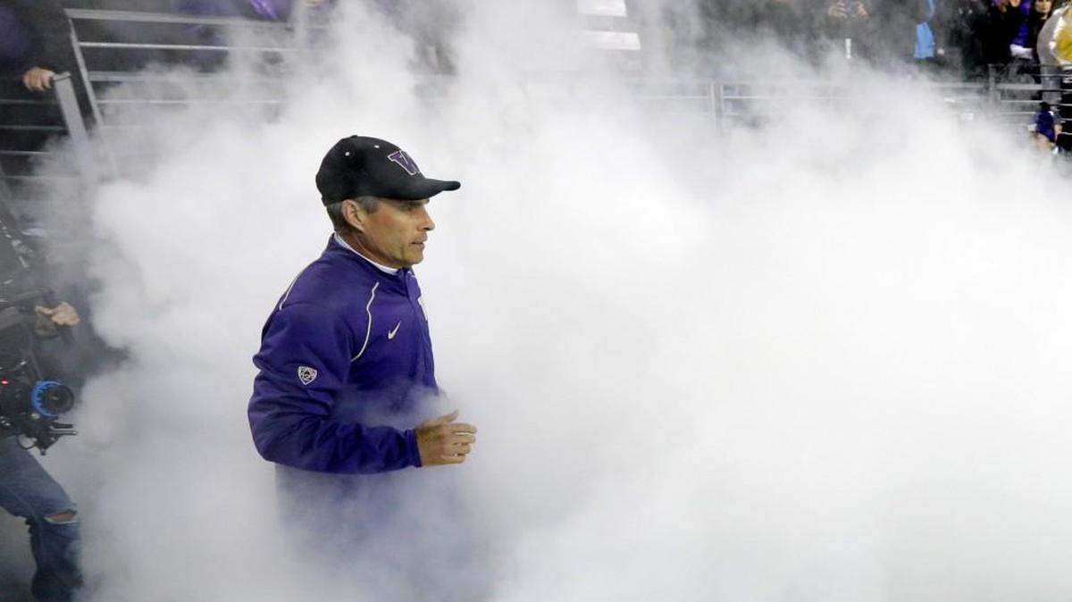 Washington head coach Chris Petersen runs onto the field through a foggy cloud before an NCAA college football game against Arizona Saturday, Oct. 31, 2015, in Seattle.