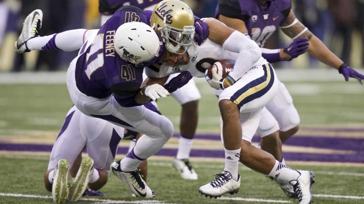 Washington linebacker Travis Feeney knocks the helmet of UCLA wide receiver Jordan Payton during a Nov. 8, 2014 game in Seattle. Feeney was selected by the Pittsburgh Steelers on Saturday with the 220th overall pick in the sixth round.