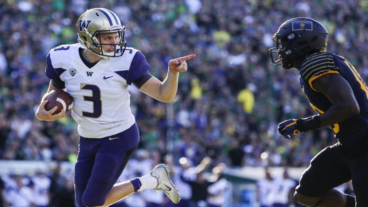 Washington quarterback Jake Browning (3) points to Oregon's Jimmie Swain (18) while rushing for a touchdown in the first quarter. The Washington Huskies played the Oregon Ducks in a football game at Autzen Stadium in Eugene, Ore., on Saturday, October 8, 2016.