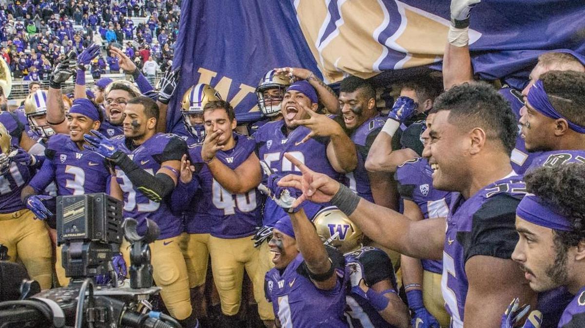 Huskies players gather to celebrate after winning the Apple Cup in Husky Stadium, November 27, 2015. UW Huskies beat the WSU Cougars 45-10.