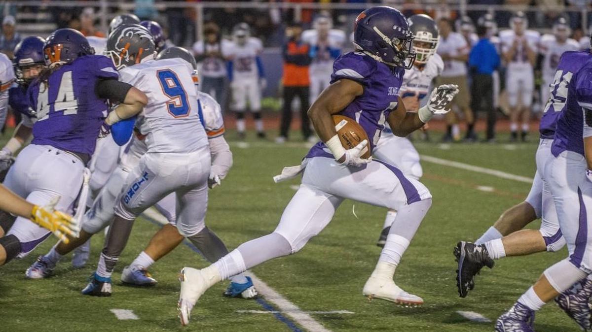 Running back Connor Wedington of Sumner High School runs past Auburn Mountainview defenders for a big gain at Sunset Chev Stadium in Sumner, September 25, 2015.