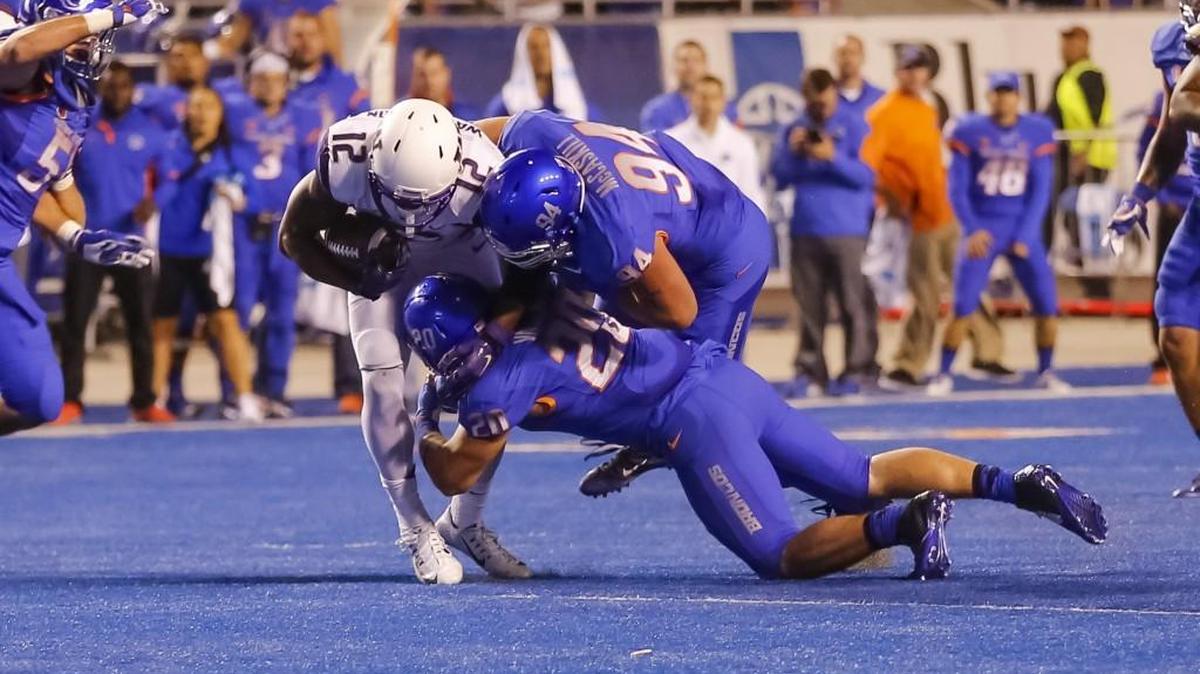 
Washington running back Dwayne Washington (12) gets tackled by Boise State’s Sam McCaskill (94) and Tanner Vallejo during the second half Friday. The Broncos held the Huskies to 29 rushing yards on 22 carries.
