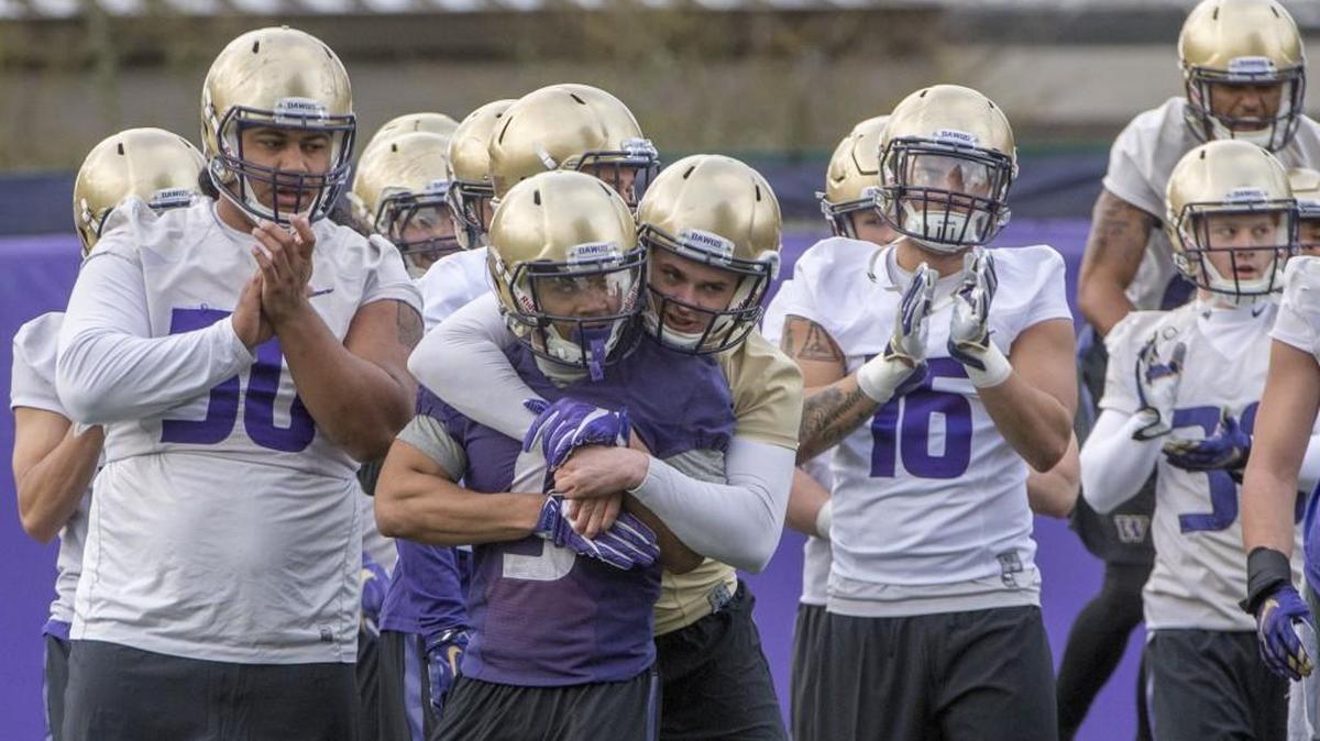 Jake Browning, QB, hugs Myles Gaskin, RB in UW football spring training at Husky Stadium, March 27, 2017.