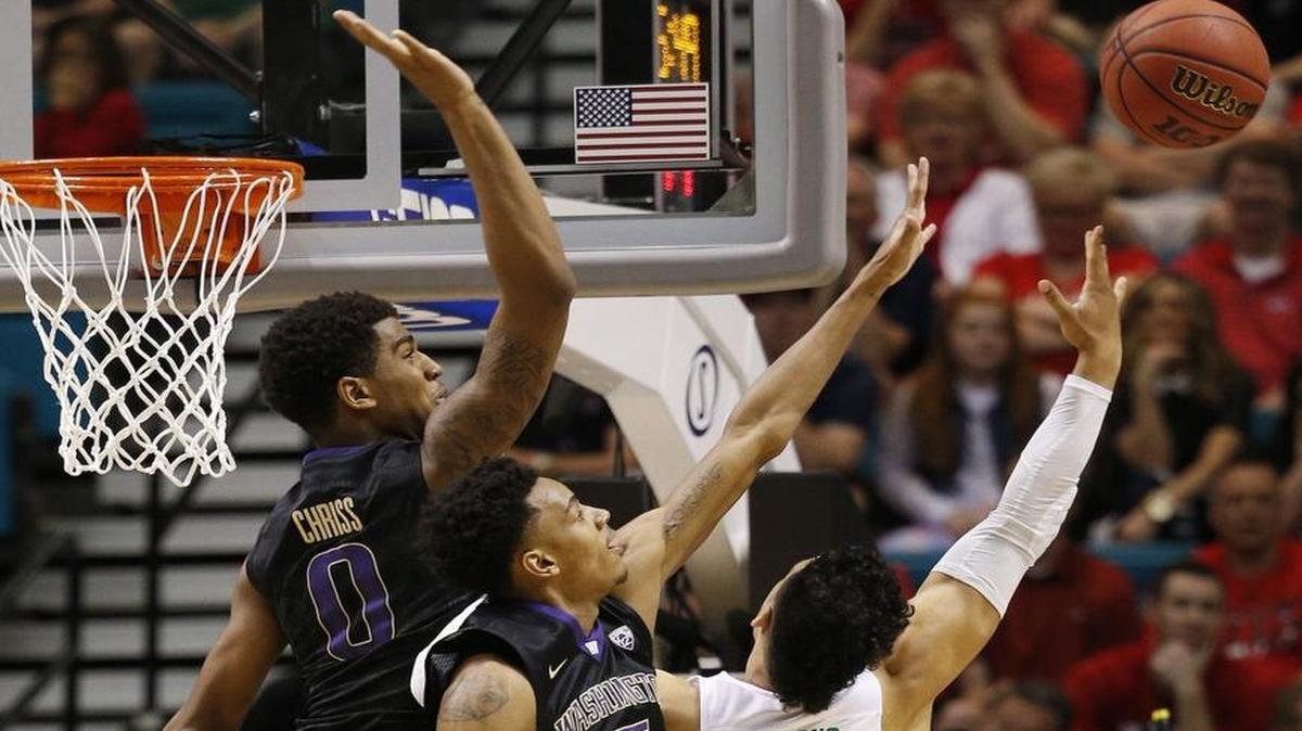 Washington guard Dejounte Murray (5) and Washington forward Marquese Chriss (0) defend as Oregon forward Dillon Brooks shoots during the first half of a quarterfinal game at the Pac-12 tournament March 10 in Las Vegas.