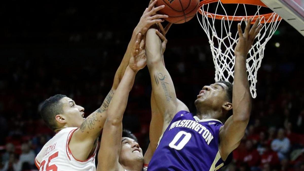 Washington forward Marquese Chriss (0) pulls down a rebound as Utah's Kyle Kuzma (35) and Chris Reyes, center, defend in the first half during an NCAA college basketball game Wednesday, Feb. 10, 2016, in Salt Lake City.