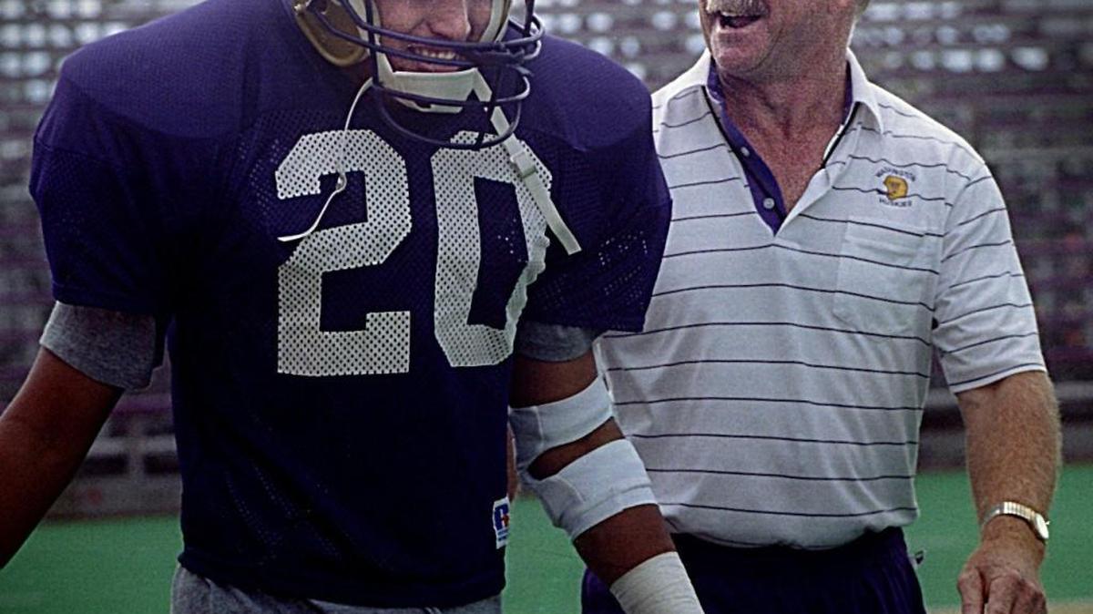Ikaika Malloe — shown here in his playing days with Washington next to Husky coach Jim Lambright, right, in August 1994 — was hired as the Huskies’ new defensive line coach Tuesday.