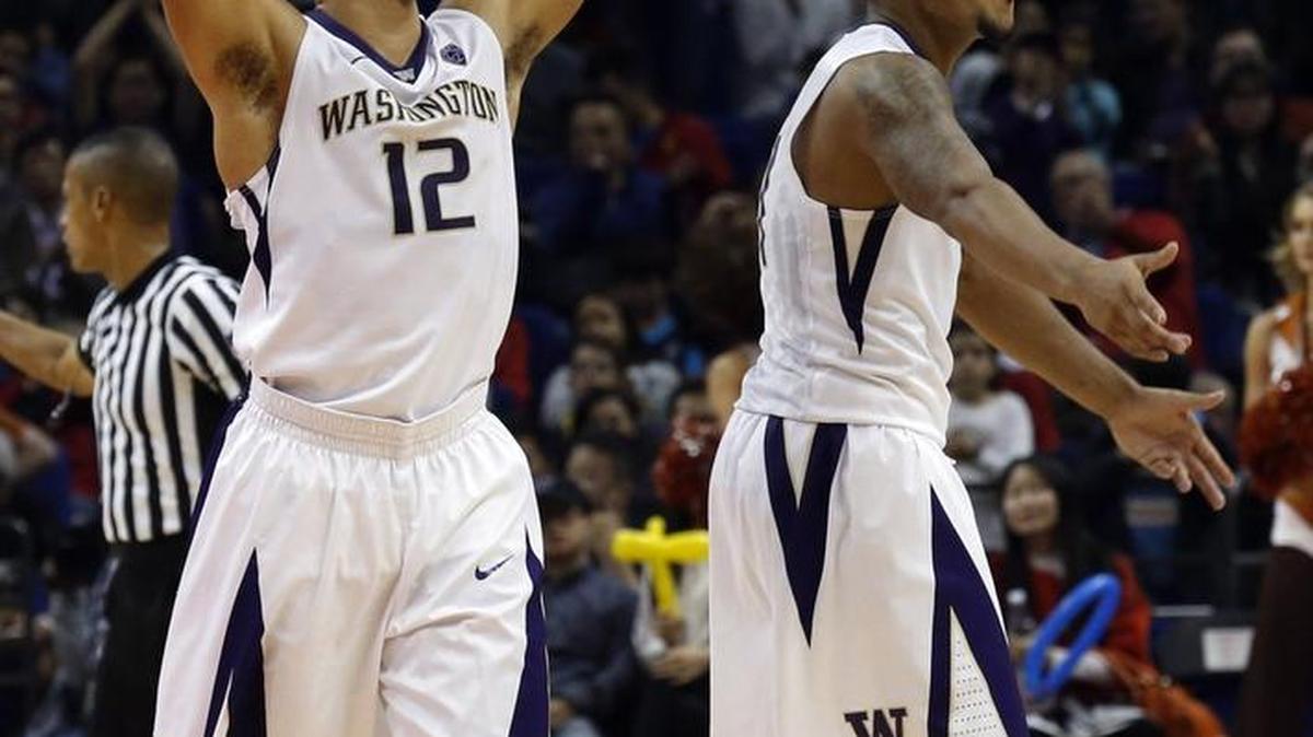Andrew Andrews of the Huskies, left, and teammate David Crisp during Washington’s game against Texas in Shanghai, China Nov. 14.