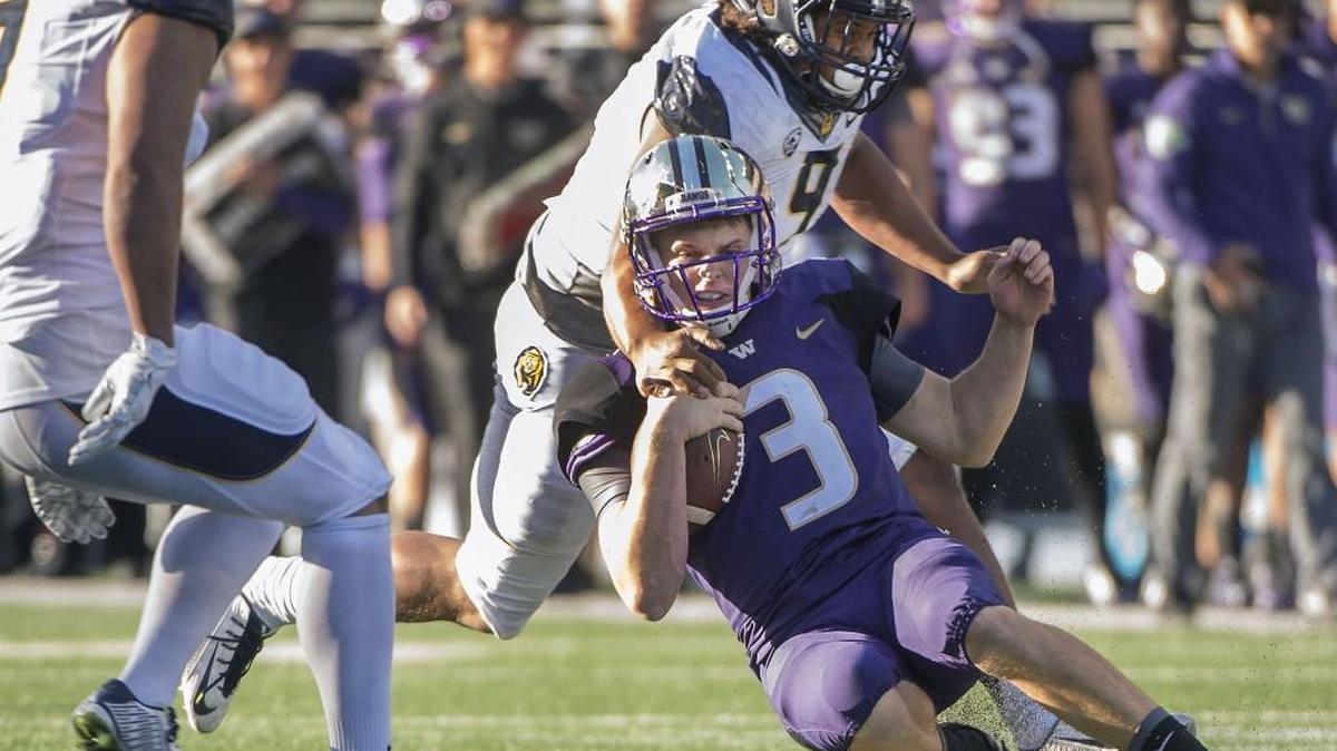
Huskies quarterback Jake Browning is taken to the ground by Cal defender James Looney. 
