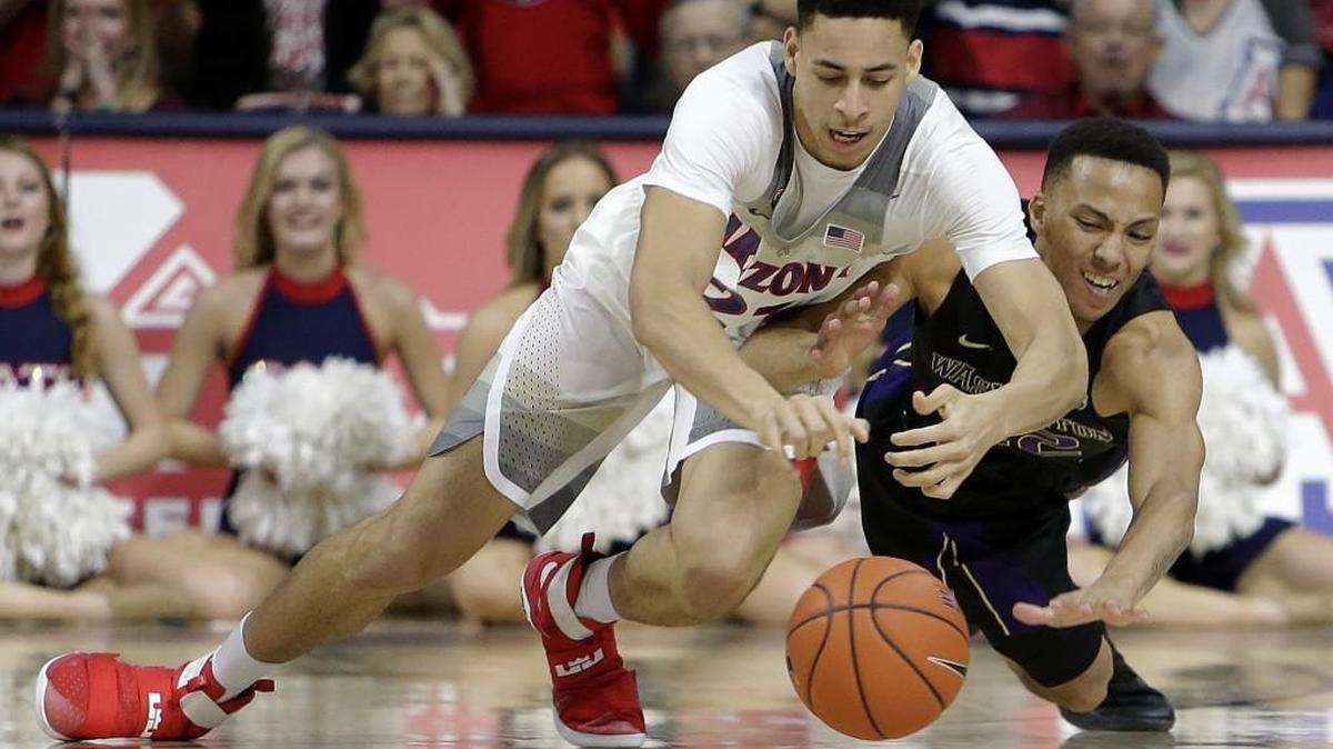 Arizona center Chance Comanche, left, and Washington forward Dominic Green battle for a loose ball during the first half of an NCAA college basketball game, Sunday, Jan. 29, 2017, in Tucson, Ariz.