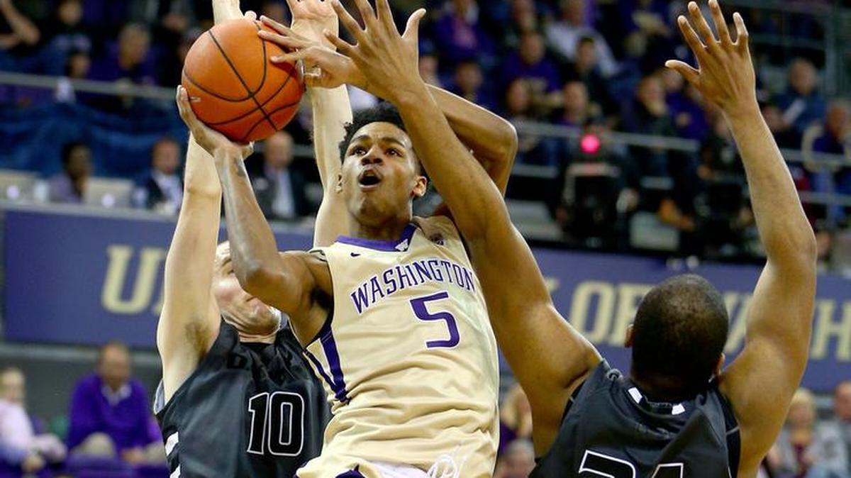 Washington’s Dejounte Murray goes up for a shot against two Oakland defenders in the first half Saturday afternoon.