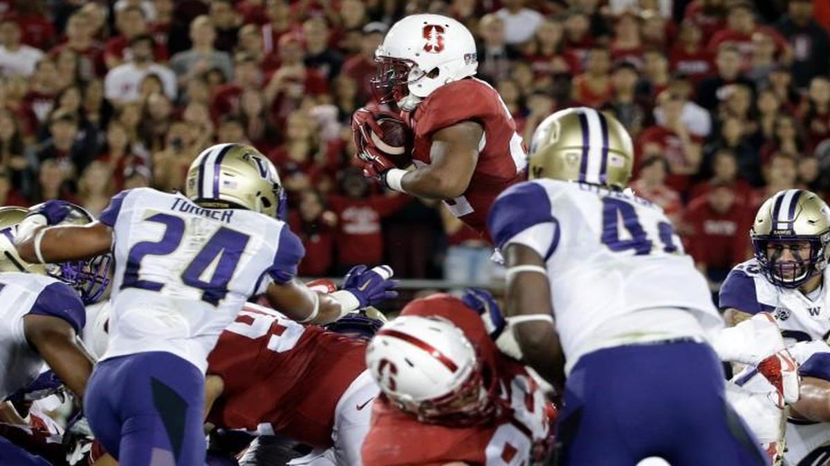 Stanford running back Remound Wright, top, leaps into the end zone for a touchdown against Washington on Saturday.