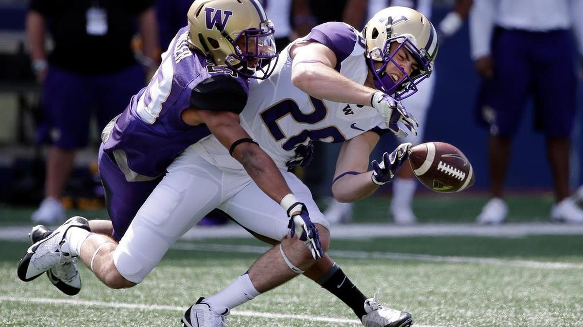 UW’s Jordan Miller, left, and Psalm Wooching compete for the ball at the team’s spring preview in April. Miller may not start at cornerback, but should see plenty of playing time. Wooching is expected to start at linebacker.