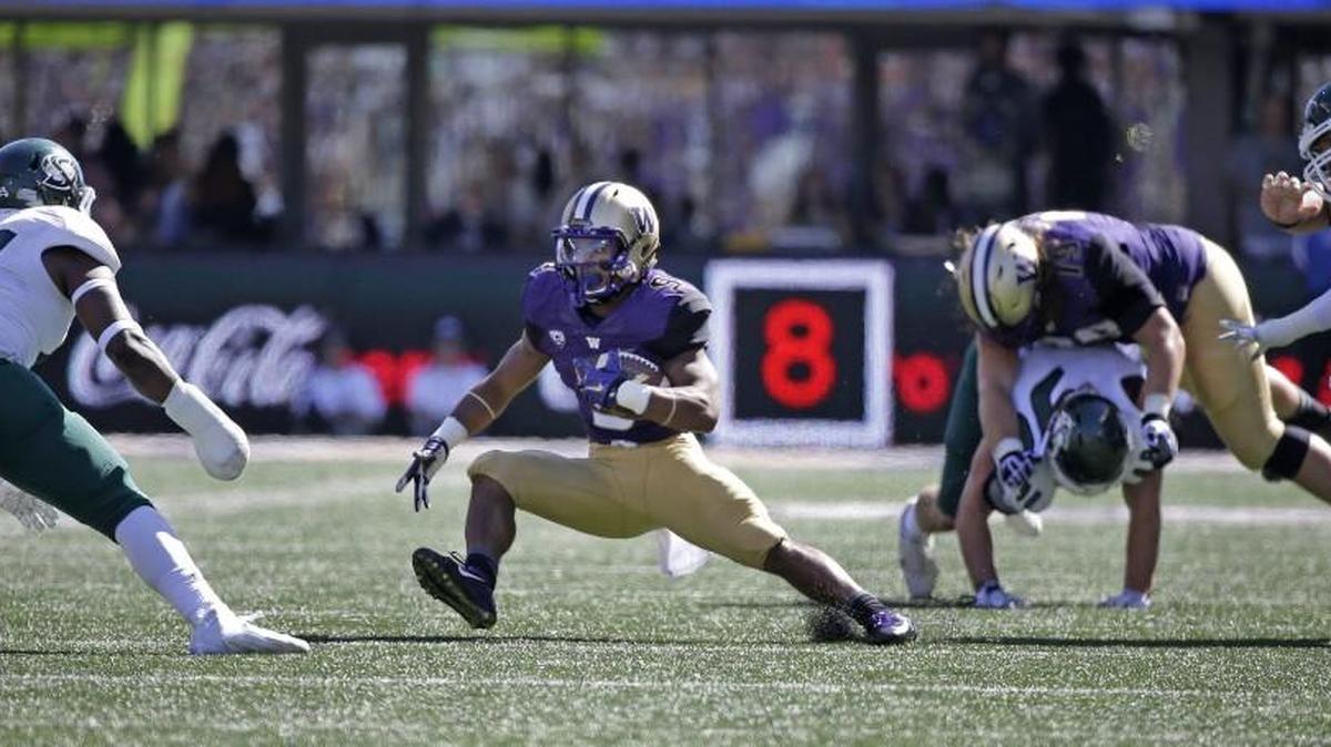 
Washington's Myles Gaskin, second left, with help from a block by another true freshman lineman, Trey Adams of Wenatchee (72), carries against Sacramento State on Saturday in Seattle.
