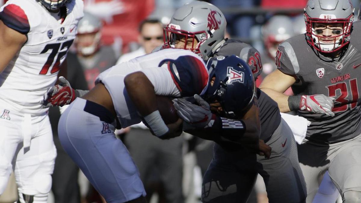 Washington State defensive lineman Nnamdi Oguayo (30) brings down Arizona quarterback Brandon Dawkins in the first half. Oguayo broke through for three of the Cougars’ five sacks last weekend in their 69-7 win in Pullman.